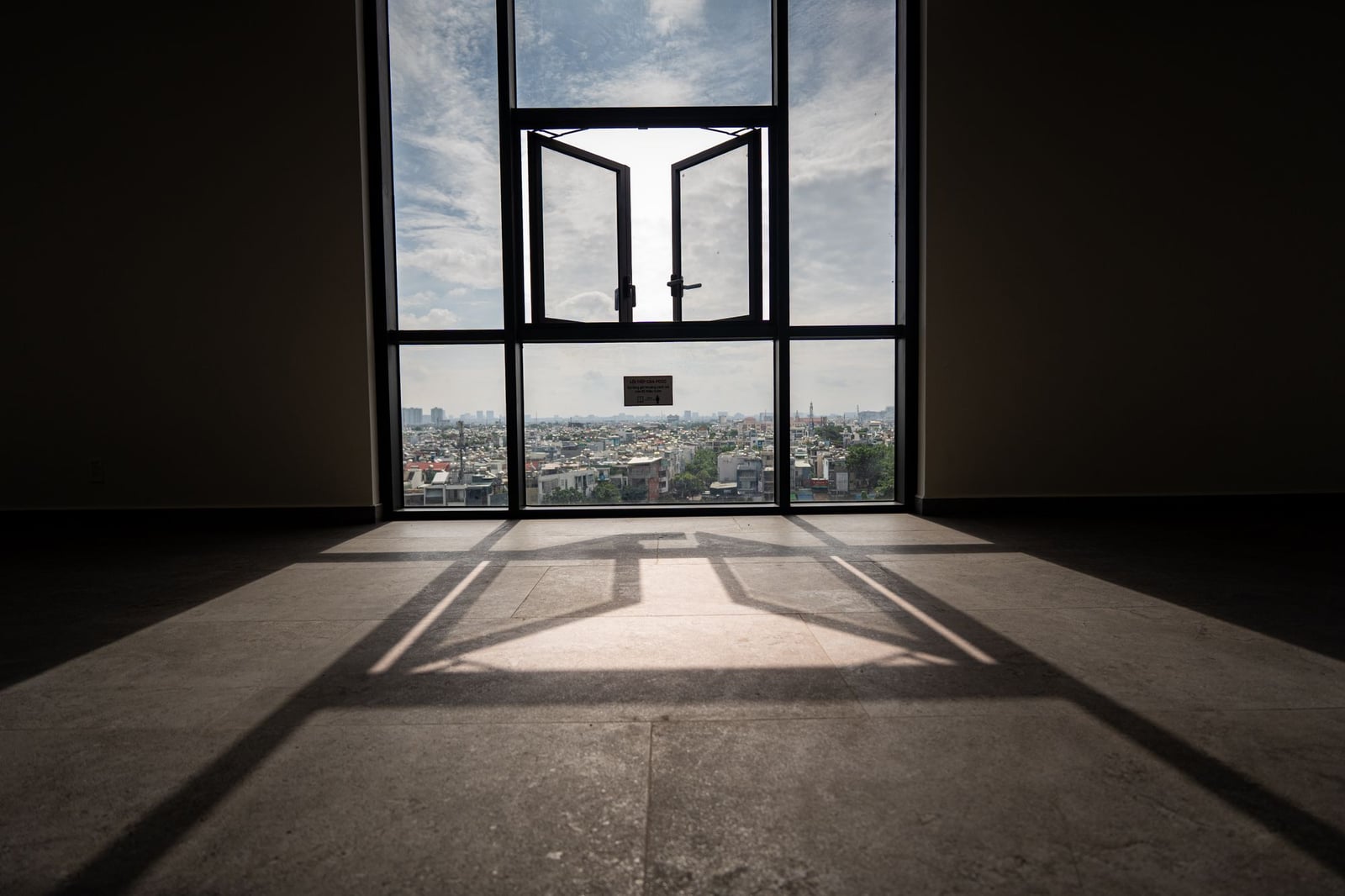 Room shot against a large window, walls and floor fall into black.