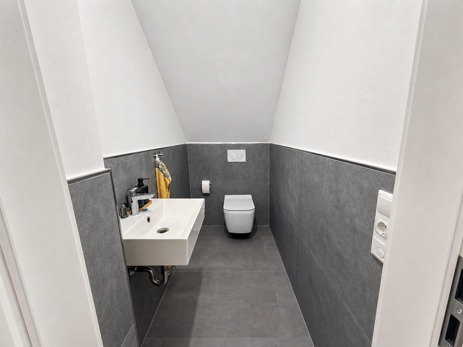 Badezimmer nachher: klar aufgehellt, Fliesen und Waschbecken sauber.