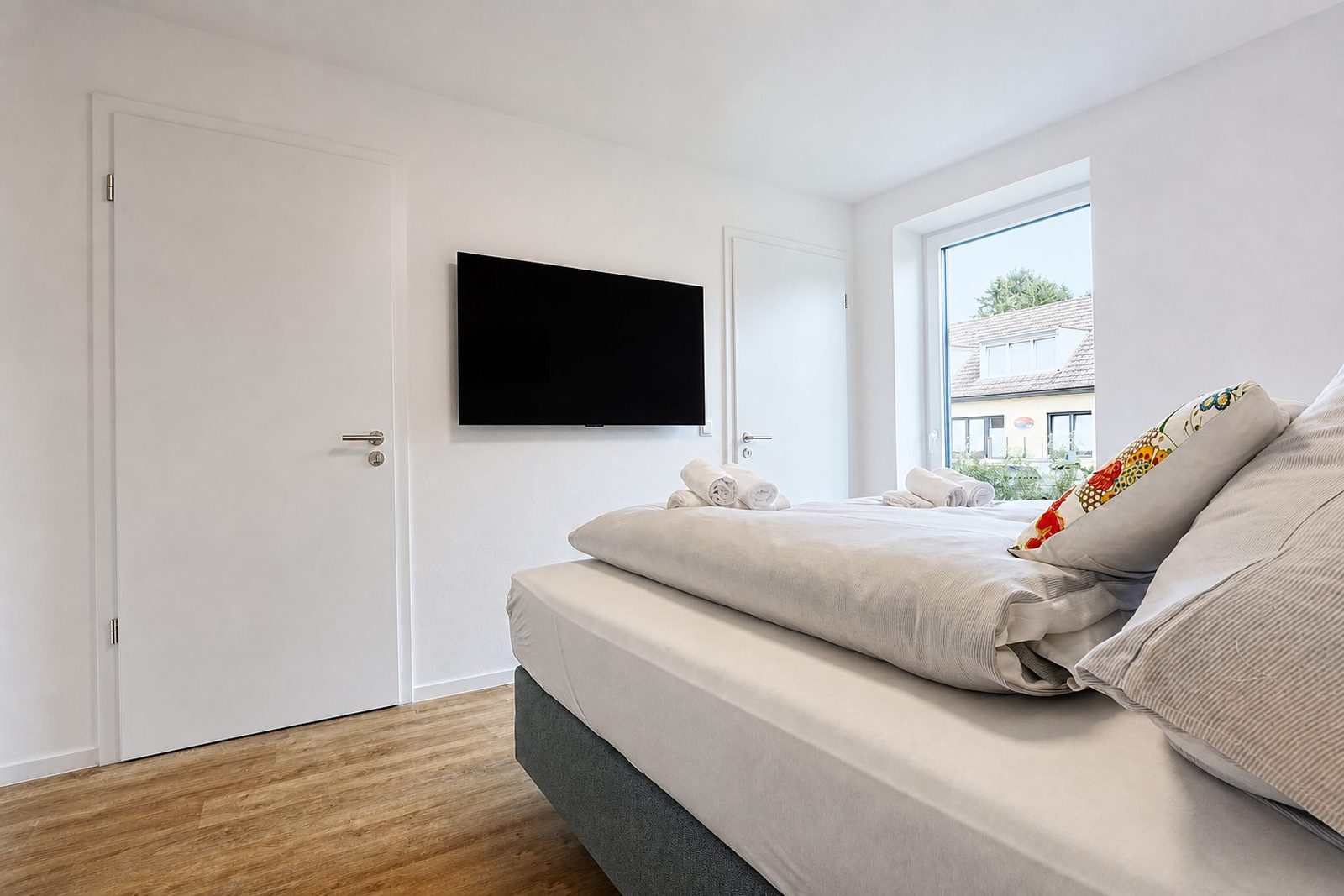 Schlafzimmer nachher: ausgeglichenes Licht trotz Fenster, Raum hell.