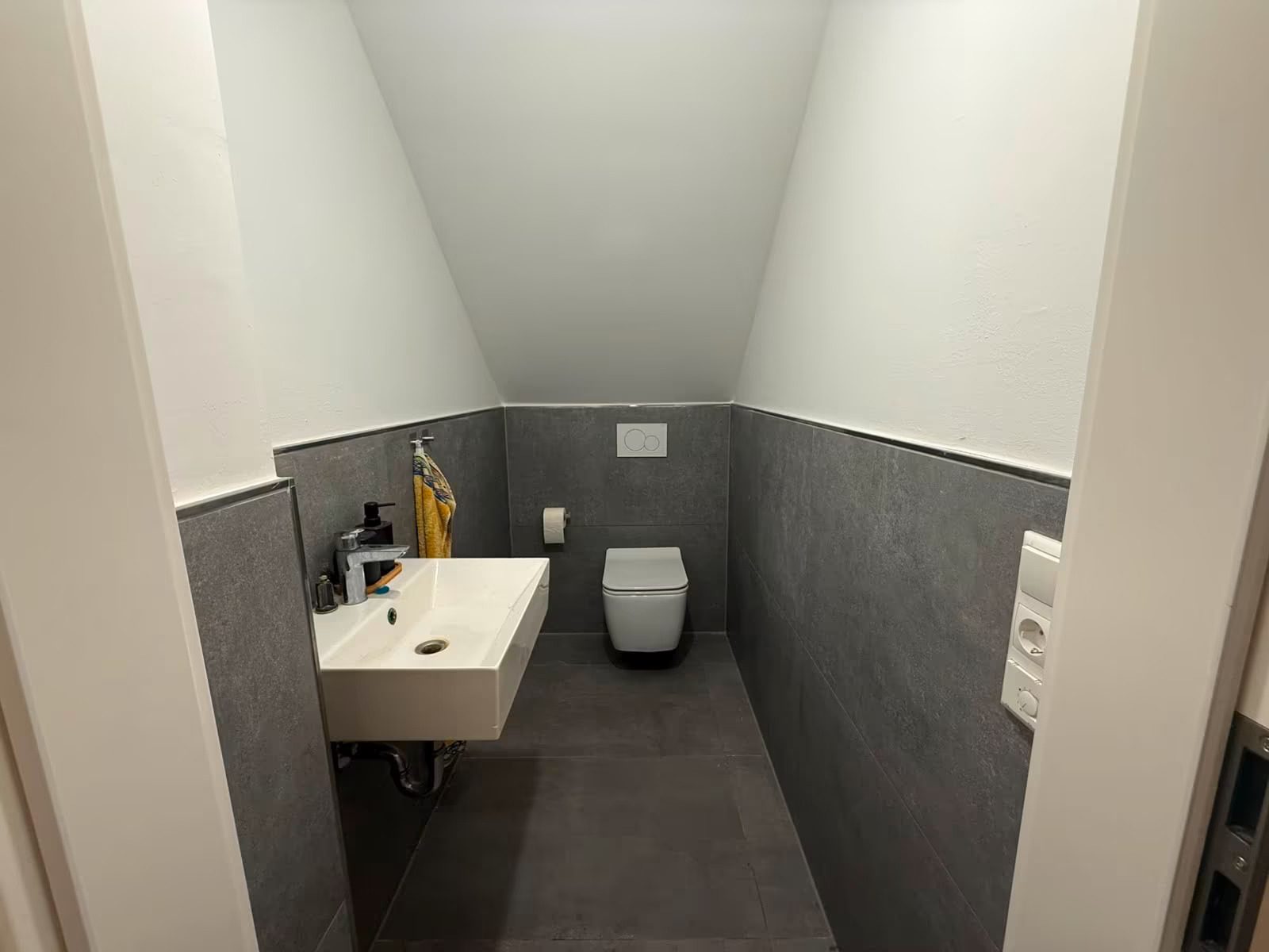 Badezimmer vorher: flaches Licht, Grautöne wirken stumpf.