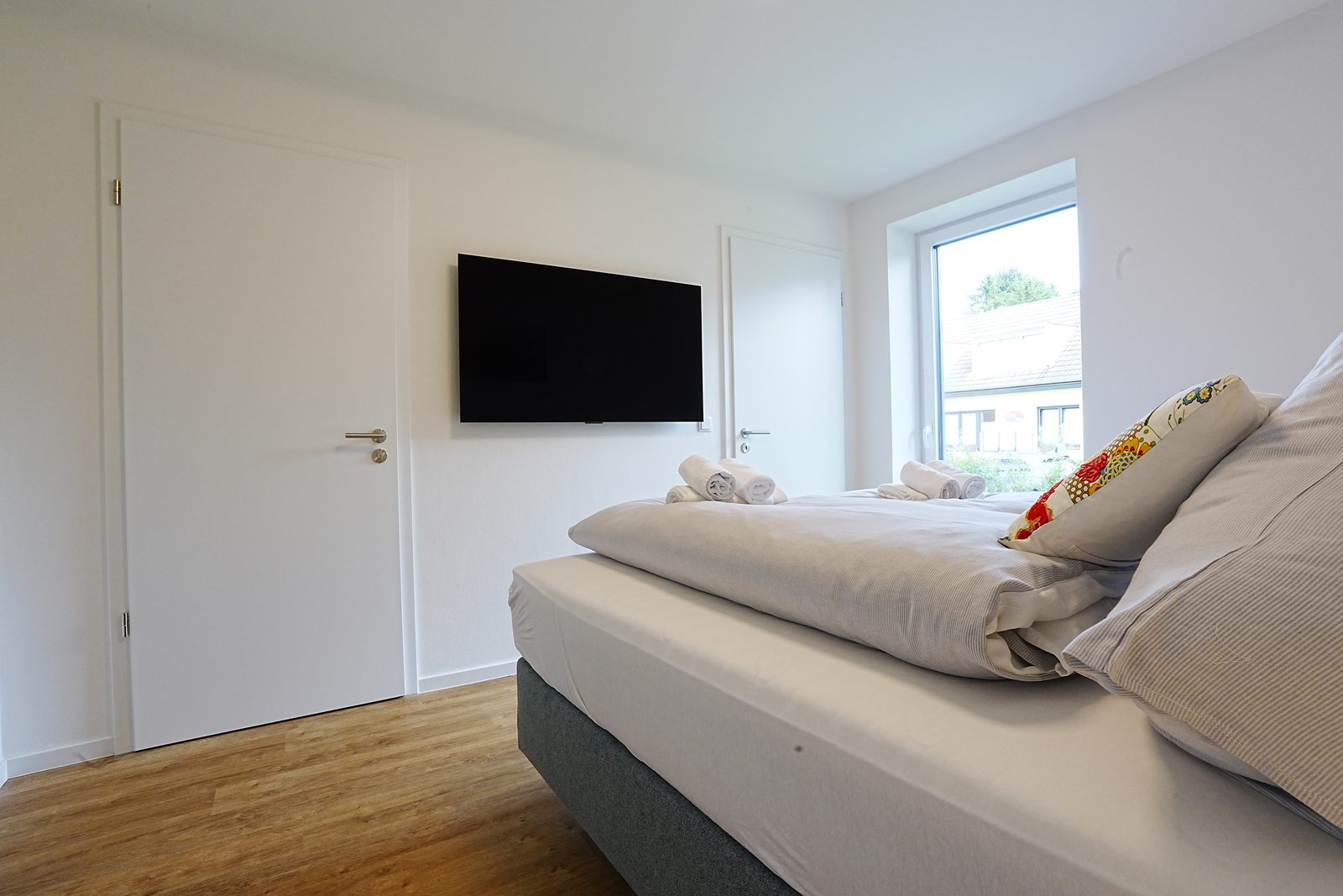 Schlafzimmer vorher: Gegenlicht vom Fenster, Raum wirkt dunkel.